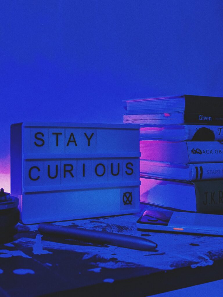 Stay Curious pink purple books sign